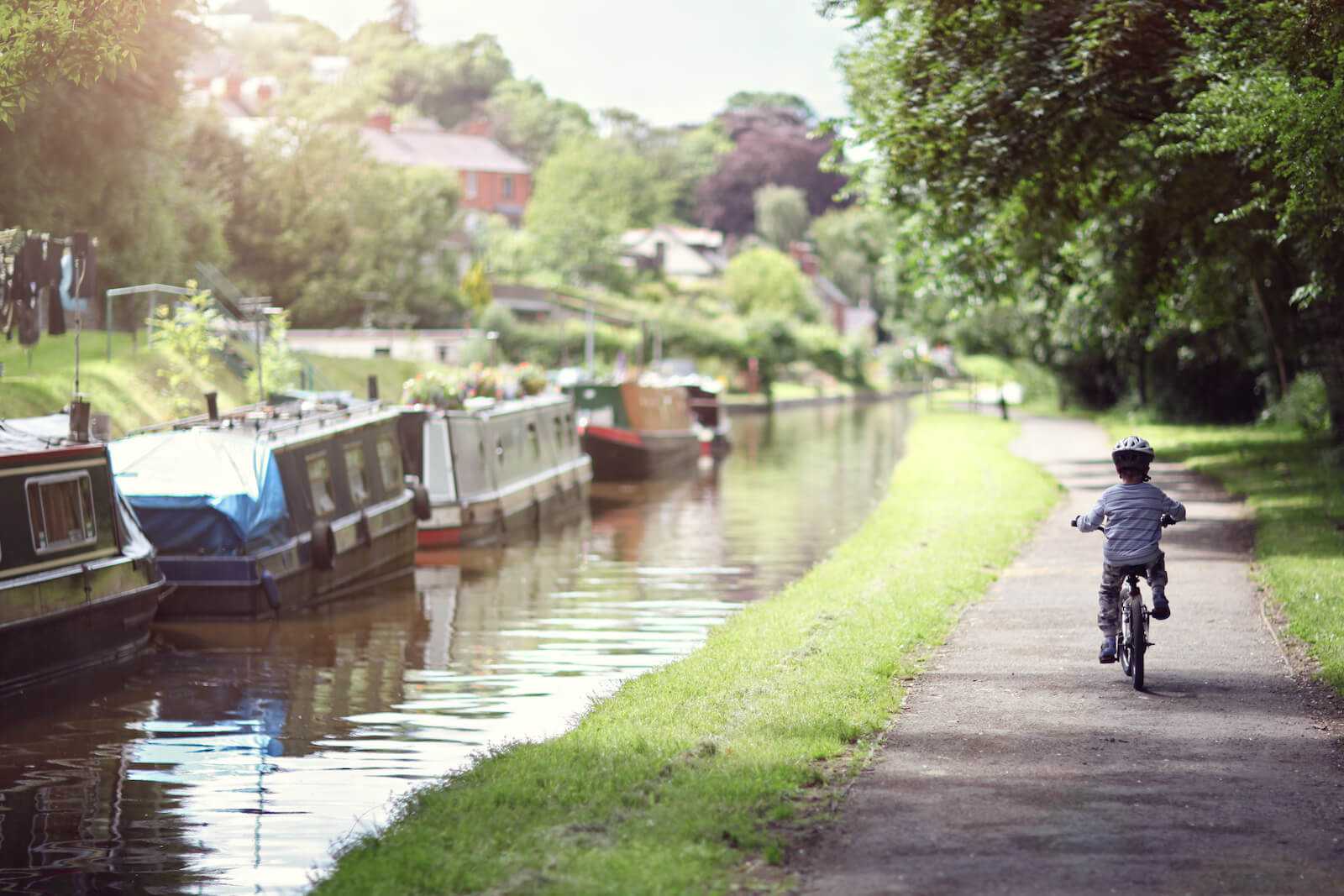 oy riding his bike along canal tow path