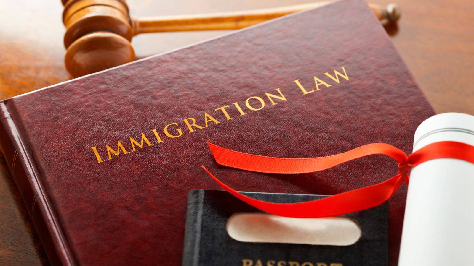 Immigration Law book, UK passport, and gavel representing UK immigration legal services