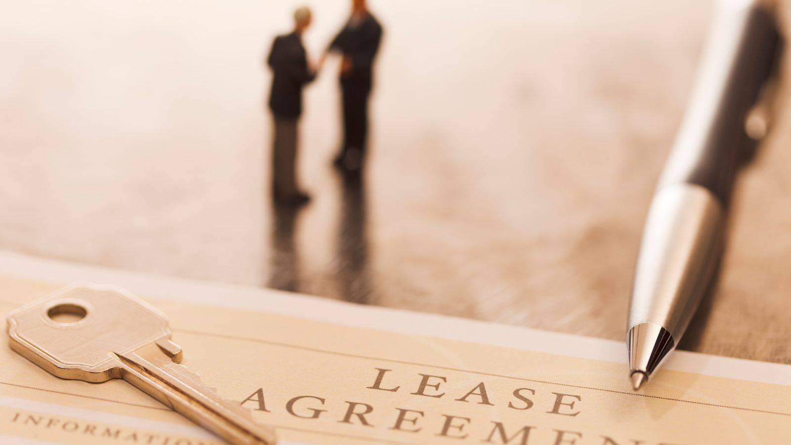 Key, lease agreement document, and pen symbolizing UK real estate legal services